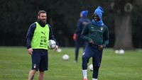 Mario Balotelli tersenyum bareng asisten pelatih Italia dan mantan rekan setimnya di Azzurri, Daniele De Rossi. (Foto: Getty Images/Claudio Villa)