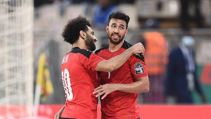 Egypts midfielder Mahmoud Trezeguet Hassan (R) celebrates with Egypts forward Mohamed Salah after scoring his teams second goal   during the Africa Cup of Nations (CAN) 2021 quarter-final football match between Egypt and Morocco at Stade Ahmadou Ahidjo in Yaounde on January 30, 2022. (Photo by CHARLY TRIBALLEAU / AFP)