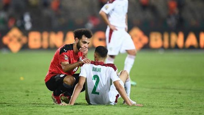 Egypts forward Mohamed Salah (L) reacts with Moroccos defender Achraf Hakimi after winning the  Africa Cup of Nations (CAN) 2021 quarter-final football match between Egypt and Morocco at Stade Ahmadou Ahidjo in Yaounde on January 30, 2022. (Photo by CHARLY TRIBALLEAU / AFP)