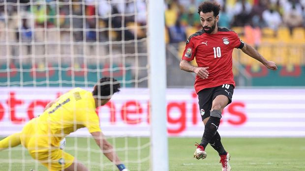 Egypt's forward Mohamed Salah (R) shoots and scores his team's first goal during the Africa Cup of Nations (CAN) 2021 quarter-final football match between Egypt and Morocco at Stade Ahmadou Ahidjo in Yaounde on January 30, 2022. (Photo by Kenzo Tribouillard / AFP)