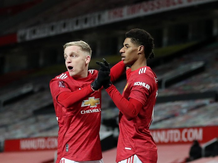 MANCHESTER, ENGLAND - JANUARY 24: Marcus Rashford of Manchester United celebrates after scoring their sides second goal with team mate Donny van de Beek during The Emirates FA Cup Fourth Round match between Manchester United and Liverpool at Old Trafford on January 24, 2021 in Manchester, England. Sporting stadiums around the UK remain under strict restrictions due to the Coronavirus Pandemic as Government social distancing laws prohibit fans inside venues resulting in games being played behind closed doors. (Photo by Martin Rickett - Pool/Getty Images)