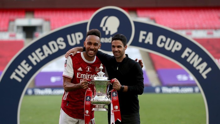 LONDON, ENGLAND - AUGUST 01: Pierre-Emerick Aubameyang of Arsenal poses with Mikel Arteta, Manager of Arsenal and the FA Cup Trophy after their teams victory in the Heads Up FA Cup Final match between Arsenal and Chelsea at Wembley Stadium on August 01, 2020 in London, England. Football Stadiums around Europe remain empty due to the Coronavirus Pandemic as Government social distancing laws prohibit fans inside venues resulting in all fixtures being played behind closed doors. (Photo by Catherine Ivill/Getty Images)