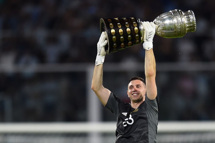 Emiliano Martinez CORDOBA, ARGENTINA - FEBRUARY 01: Emiliano Martinez goalkeeper of Argentina celebrates with the Copa America 2021 trophy after winning a match between Argentina and Colombia as part of FIFA World Cup Qatar 2022 Qualifiers at Mario Alberto Kempes Stadium on February 01, 2022 in Cordoba, Argentina. (Photo by Marcelo Endelli/Getty Images)