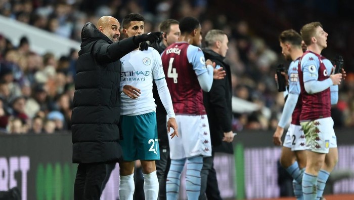 BIRMINGHAM, ENGLAND - DECEMBER 01: Pep Guardiola, Manager of Manchester City talks with Joao Cancelo of Manchester City during the Premier League match between Aston Villa and Manchester City at Villa Park on December 01, 2021 in Birmingham, England. (Photo by Shaun Botterill/Getty Images)