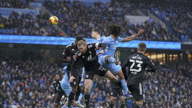 Manchester City's John Stones, background center, scores his side's second goal during an English FA Cup fourth round soccer match between Manchester City and Fulham at the Etihad Stadium in Manchester, England, Saturday, Feb. 5, 2022. (AP Photo/Jon Super)