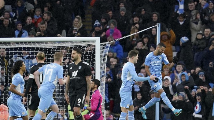 Manchester Citys Riyad Mahrez, right, celebrates after scoring his sides third goal from the penalty spot during an English FA Cup fourth round soccer match between Manchester City and Fulham at the Etihad Stadium in Manchester, England, Saturday, Feb. 5, 2022. (AP Photo/Jon Super)