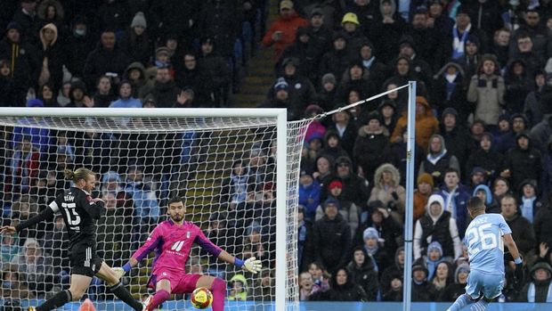Manchester City's Riyad Mahrez, right, scores his side's fourth goal during an English FA Cup fourth round soccer match between Manchester City and Fulham at the Etihad Stadium in Manchester, England, Saturday, Feb. 5, 2022. (AP Photo/Jon Super)