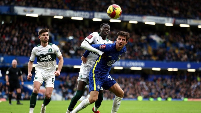 LONDON, ENGLAND - FEBRUARY 05: Mason Mount of Chelsea holds off pressure from Panutche Camara of Plymouth during the Emirates FA Cup Fourth Round match between Chelsea and Plymouth Argyle at Stamford Bridge on February 05, 2022 in London, England. (Photo by Bryn Lennon/Getty Images)