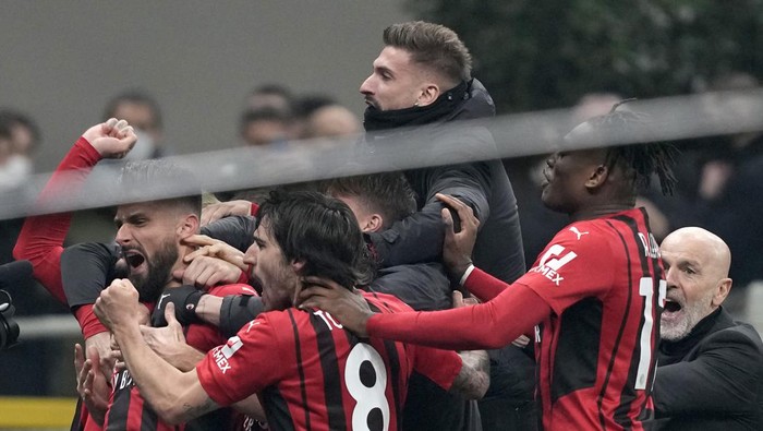 AC Milans Olivier Giroud, left, celebrates with teammates after scoring his sides second goal during the Serie A soccer match between Inter Milan and AC Milan at the San Siro Stadium, in Milan, Italy, Saturday, Feb. 5, 2022. (AP Photo/Antonio Calanni)