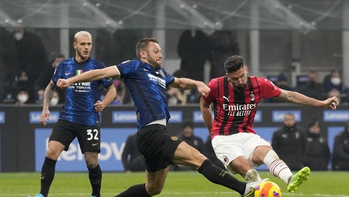 AC Milans Olivier Giroud, right, scores his sides second goal during the Serie A soccer match between Inter Milan and AC Milan at the San Siro Stadium, in Milan, Italy, Saturday, Feb. 5, 2022. (AP Photo/Antonio Calanni)