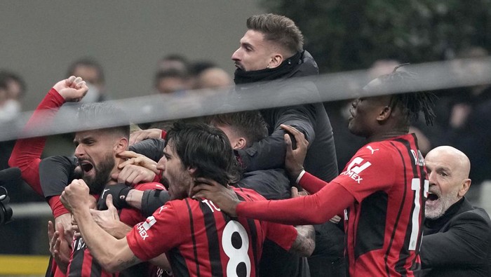 AC Milan's Olivier Giroud, left, celebrates with teammates after scoring his side's second goal during the Serie A soccer match between Inter Milan and AC Milan at the San Siro Stadium, in Milan, Italy, Saturday, Feb. 5, 2022. (AP Photo/Antonio Calanni)