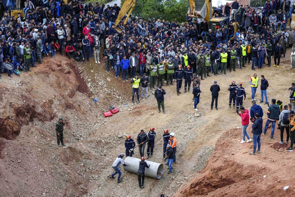 The parents of 5-year-old Rayan walk toward an ambulance after seeing their son's retrieved body after he fell into a hole and was stuck there for several days, in the village of Ighran in Morocco's Chefchaouen province, Saturday, Feb. 5, 2022. The boy died and was pulled out Saturday night by rescuers after a lengthy operation that captivated global attention. (AP Photo/Mosa'ab Elshamy)