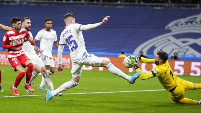 Real Madrids Federico Valverde, left, and Granadas goalkeeper Luis Maximiano vie for the ball during a Spanish La Liga soccer match between Real Madrid and Granada at the Bernabeu stadium in Madrid, Spain, Sunday, Feb. 6, 2022. (AP Photo/Manu Fernandez)