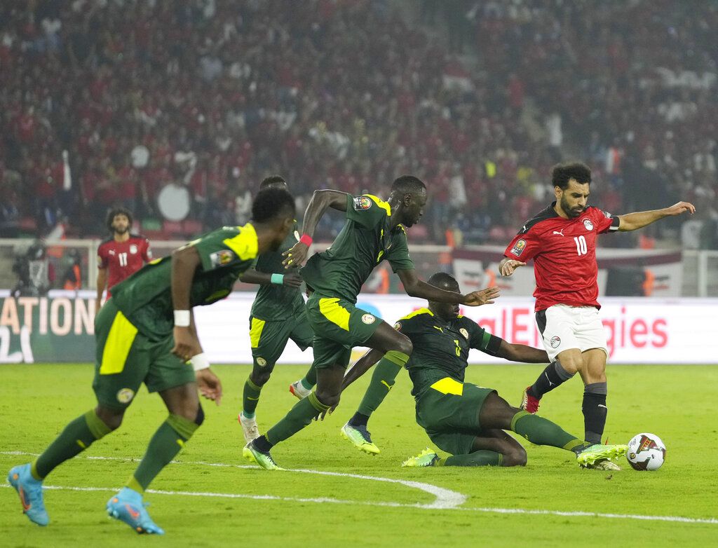 Senegal's Kalidou Koulibaly, bottom, kicks the ball as he defends against Egypt's Mohamed Salah, right, during the African Cup of Nations 2022 final soccer match between Senegal and Egypt at the Ahmadou Ahidjo stadium in Yaounde, Cameroon, Sunday, Feb. 6, 2022. (AP Photo/Themba Hadebe)