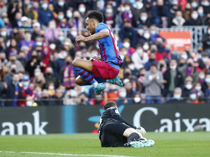 Atletico Madrids goalkeeper Jan Oblak, bottom, makes a save in front Barcelonas Pierre-Emerick Aubameyang during a Spanish La Liga soccer match between FC Barcelona and Atletico Madrid at the Camp Nou stadium in Barcelona, Spain, Sunday, Feb. 6, 2022. (AP Photo/Joan Monfort)