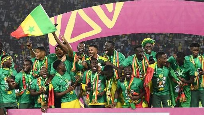 Senegals players celebrate after winning the Africa Cup of Nations (CAN) 2021 final football match between Senegal and Egypt at Stade dOlembe in Yaounde on February 6, 2022. (Photo by CHARLY TRIBALLEAU / AFP)