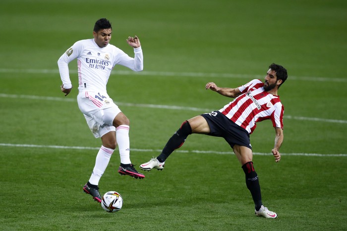 MALAGA, SPAIN - JANUARY 14: Casemiro of Real Madrid battles for possession with Raul Garcia of Athletic Bilbao  during the Supercopa de Espana Semi Final match between Real Madrid and Athletic Club at Estadio La Rosaleda on January 14, 2021 in Malaga, Spain. Sporting stadiums around Spain remain under strict restrictions due to the Coronavirus Pandemic as Government social distancing laws prohibit fans inside venues resulting in games being played behind closed doors. (Photo by Fran Santiago/Getty Images)