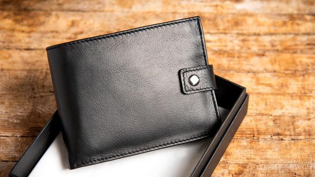 Black leather wallet on a wooden table top view