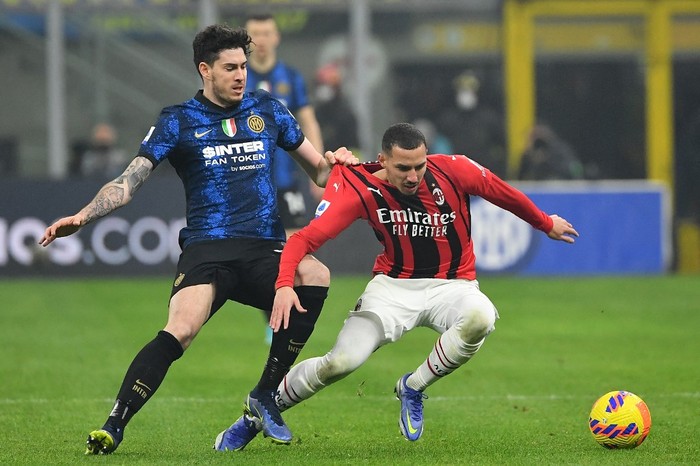 AC Milans Algerian midfielder Ismael Bennacer (R) fights for the ball with Inter Milans Italian defender Alessandro Bastoni (L) during the Italian Serie A football match between Inter Milan and AC Milan at the Giuseppe-Meazza (San Siro) stadium in Milan on February 5, 2022. (Photo by Isabella BONOTTO / AFP)