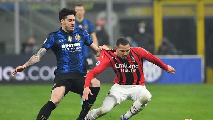 AC Milans Algerian midfielder Ismael Bennacer (R) fights for the ball with Inter Milans Italian defender Alessandro Bastoni (L) during the Italian Serie A football match between Inter Milan and AC Milan at the Giuseppe-Meazza (San Siro) stadium in Milan on February 5, 2022. (Photo by Isabella BONOTTO / AFP)