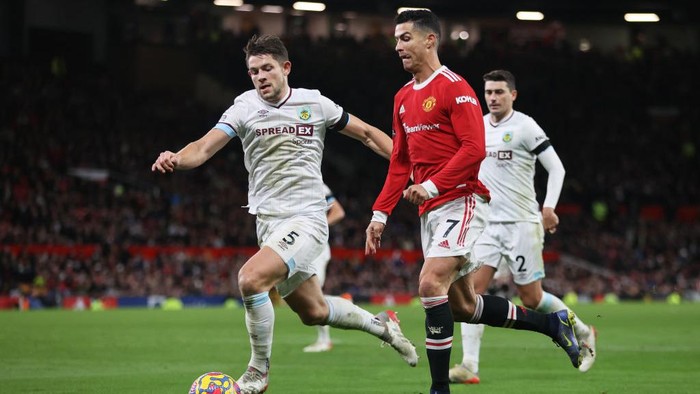 MANCHESTER, ENGLAND - DECEMBER 30: Cristiano Ronaldo of Manchester United is challenged by James Tarkowski of Burnley during the Premier League match between Manchester United and Burnley at Old Trafford on December 30, 2021 in Manchester, England. (Photo by Clive Brunskill/Getty Images)