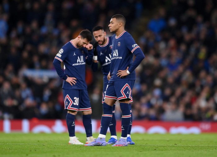 MANCHESTER, ENGLAND - NOVEMBER 24: Kylian Mbappe of Paris Saint-Germain looks on as teammates Lionel Messi and Neymar talk in the background after Manchester Citys first goal during the UEFA Champions League group A match between Manchester City and Paris Saint-Germain at Etihad Stadium on November 24, 2021 in Manchester, England. (Photo by Laurence Griffiths/Getty Images)
