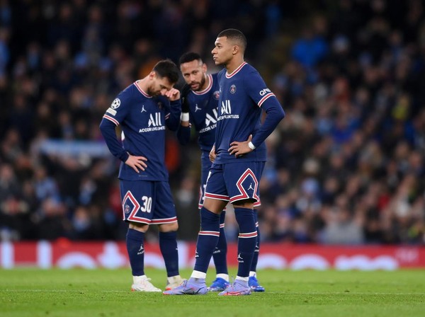 MANCHESTER, ENGLAND - NOVEMBER 24: Kylian Mbappe of Paris Saint-Germain looks on as teammates Lionel Messi and Neymar talk in the background after Manchester Citys first goal during the UEFA Champions League group A match between Manchester City and Paris Saint-Germain at Etihad Stadium on November 24, 2021 in Manchester, England. (Photo by Laurence Griffiths/Getty Images)