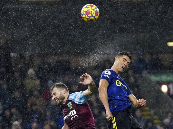 Manchester Uniteds Cristiano Ronaldo, right, jumps for the ball with Burnleys Erik Pieters during the English Premier League soccer match between Burnley and Manchester United at Turf Moor, in Burnley, England, Tuesday, Feb. 8, 2022. (AP Photo/Jon Super)