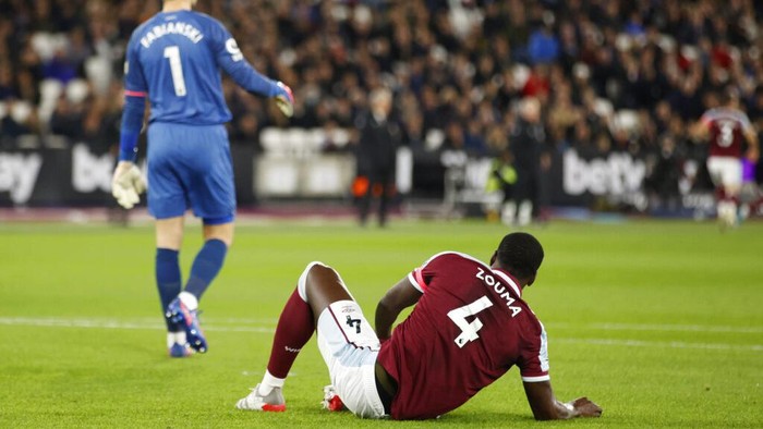 West Hams Kurt Zouma, right, sits on the ground after a challenge during an English Premier League soccer match between West Ham United and Watford at the London stadium in London, Tuesday, Feb. 8, 2022. (AP Photo/David Cliff)