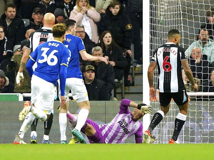 Everton's Jarrad Branthwaite, right, heads the ball clear, during the English Premier League soccer match between Newcastle United and Everton, at St James' Park, Newcastle, England, Tuesday, Feb. 8, 2022. (Owen Humphreys/PA via AP)