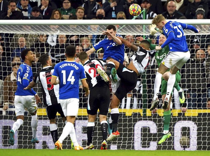 Everton's Jarrad Branthwaite, right, heads the ball clear, during the English Premier League soccer match between Newcastle United and Everton, at St James' Park, Newcastle, England, Tuesday, Feb. 8, 2022. (Owen Humphreys/PA via AP)