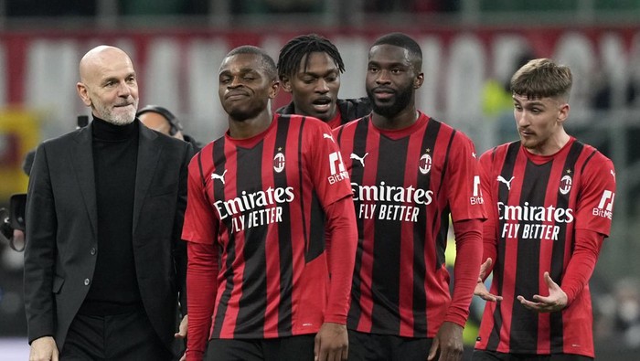 AC Milans manager Stefano Pioli, left, speaks with AC Milans Pierre Kalulu, second left, at the end of the Italian Cup quarter final match between AC Milan and Lazio at the San Siro stadium, in Milan, Italy, Wednesday, Feb. 9, 2022. (AP Photo/Antonio Calanni)