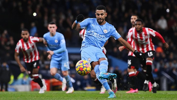 MANCHESTER, ENGLAND - FEBRUARY 09: Riyad Mahrez of Manchester City scores their sides first goal from the penalty spot during the Premier League match between Manchester City and Brentford at Etihad Stadium on February 09, 2022 in Manchester, England. (Photo by Gareth Copley/Getty Images)
