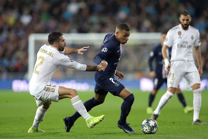 MADRID, SPAIN - NOVEMBER 26: Kylian Mbappe of Paris Saint-Germain runs with the ball past Daniel Carvajal of Real Madrid during the UEFA Champions League group A match between Real Madrid and Paris Saint-Germain at Bernabeu on November 26, 2019 in Madrid, Spain. (Photo by Angel Martinez/Getty Images)
