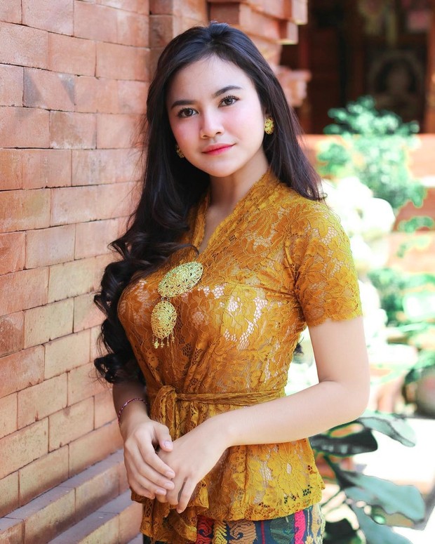 Pada sebuah acara sakral Mahalini tampak mengankan kebaya brokat berwarna emas.