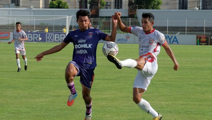 Pesepak bola Persita Kasim Botan (kiri) berebut bola dangan pesepak bola Borneo FC Leo Guntara (kanan) pada pertandingan Liga 1 di Stadion Kompyang Sujana, Denpasar, Bali, Rabu (2/2/2022). Pertandingan tersebut berakhir imbang dengan skor 1-1. ANTARA FOTO/Nyoman Hendra Wibowo/aww.