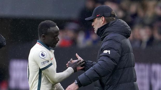 Liverpool's manager Jurgen Klopp, right, shakes hands with Liverpool's Sadio Mane during the English Premier League soccer match between Burnley and Liverpool at Turf Moor, in Burnley, England, Sunday, Feb. 13, 2022. (AP Photo/Jon Super)
