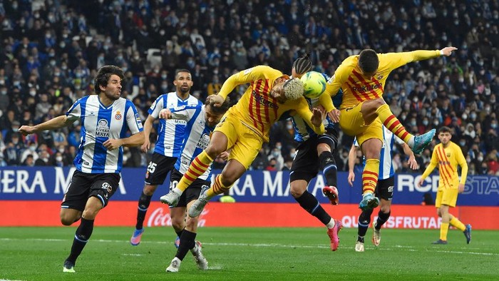 Barcelonas Uruguayan defender Ronald Araujo (L) vies with Espanyols Spanish forward Raul de Tomas (C) during the Spanish league football match between RCD Espanyol and FC Barcelona atthe RCDE Stadium in Cornella de Llobregat on February 13, 2022. (Photo by Pau BARRENA / AFP)