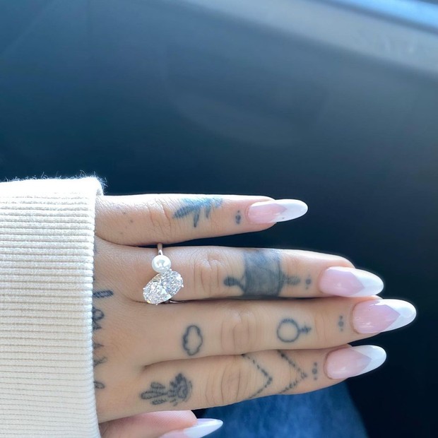 cincin pertunangan Ariana Grande mempunyai disain berlian oval-cut berdampingan dengan mutiara putih