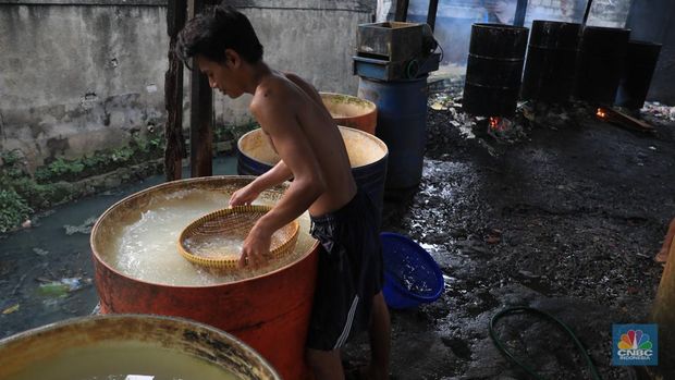 Perajin membikin tempe di industri rumahan skala mini di Jalan Wahid, Ciputat, Tangerang Selatan, Selasa, (15/2/2022). Kenaikan biaya bahan baku utama itu dilaporkan jadi penyebab berhentinya produksi sejumlah industri rumahan tempe dan tahu (CNBC Indonesia/ Muhammad Sabki