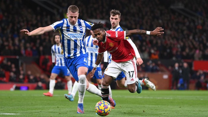 MANCHESTER, ENGLAND - FEBRUARY 15: Fred of Manchester United runs with the ball from Adam Webster and Steven Alzate of Brighton & Hove Albion during the Premier League match between Manchester United and Brighton & Hove Albion at Old Trafford on February 15, 2022 in Manchester, England. (Photo by Laurence Griffiths/Getty Images)
