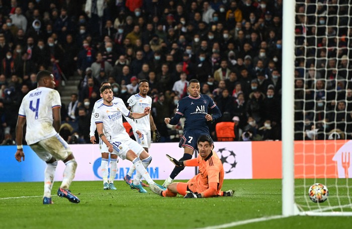 Kylian Mbappe PARIS, FRANCE - FEBRUARY 15: Kylian Mbappe of Paris Saint-Germain scores their team's first goal past Thibaut Courtois of Real Madrid during the UEFA Champions League Round Of Sixteen Leg One match between Paris Saint-Germain and Real Madrid at Parc des Princes on February 15, 2022 in Paris, France. (Photo by Shaun Botterill/Getty Images)