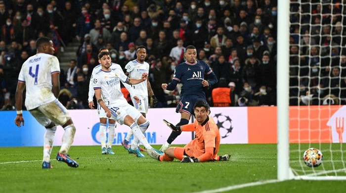 PARIS, FRANCE - FEBRUARY 15: Kylian Mbappe of Paris Saint-Germain scores their teams first goal past Thibaut Courtois of Real Madrid during the UEFA Champions League Round Of Sixteen Leg One match between Paris Saint-Germain and Real Madrid at Parc des Princes on February 15, 2022 in Paris, France. (Photo by Shaun Botterill/Getty Images)