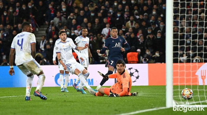 PARIS, FRANCE - FEBRUARY 15: Kylian Mbappe of Paris Saint-Germain scores their teams first goal past Thibaut Courtois of Real Madrid during the UEFA Champions League Round Of Sixteen Leg One match between Paris Saint-Germain and Real Madrid at Parc des Princes on February 15, 2022 in Paris, France. (Photo by Shaun Botterill/Getty Images)