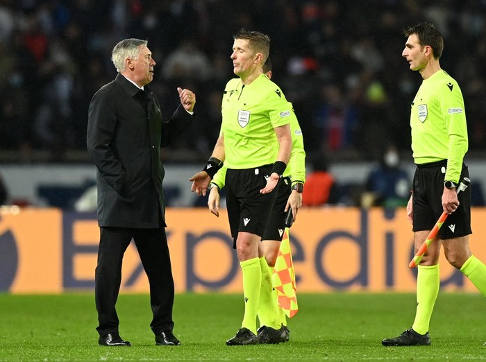 PARIS, FRANCE - FEBRUARY 15: Carlo Ancelotti, Head Coach of Real Madrid speaks to Referee Daniele Orsato after their sides defeat during the UEFA Champions League Round Of Sixteen Leg One match between Paris Saint-Germain and Real Madrid at Parc des Princes on February 15, 2022 in Paris, France. (Photo by Shaun Botterill/Getty Images)
