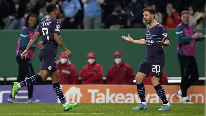 Manchester Citys Raheem Sterling, left, celabrates with Bernardo Silva, his sides fifth goal during the Champions League round of 16 soccer match between Sporting CP and Manchester City at the Alvalade stadium in Lisbon, Portugal, Tuesday, Feb. 15, 2022. (AP Photo/Armando Franca)