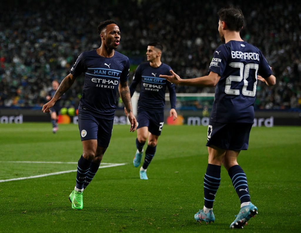 LISBON, PORTUGAL - FEBRUARY 15: Raheem Sterling celebrates with Bernardo Silva of Manchester City after scoring their team's fifth goal during the UEFA Champions League Round Of Sixteen Leg One match between Sporting CP and Manchester City at Estadio Jose Alvalade on February 15, 2022 in Lisbon , Portugal.  (Photo by Mike Hewitt/Getty Images)