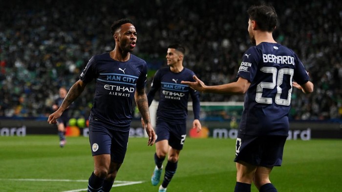 LISBON, PORTUGAL - FEBRUARY 15: Raheem Sterling celebrates with Bernardo Silva of Manchester City after scoring their teams fifth goal during the UEFA Champions League Round Of Sixteen Leg One match between Sporting CP and Manchester City at Estadio Jose Alvalade on February 15, 2022 in Lisbon, Portugal. (Photo by Mike Hewitt/Getty Images)