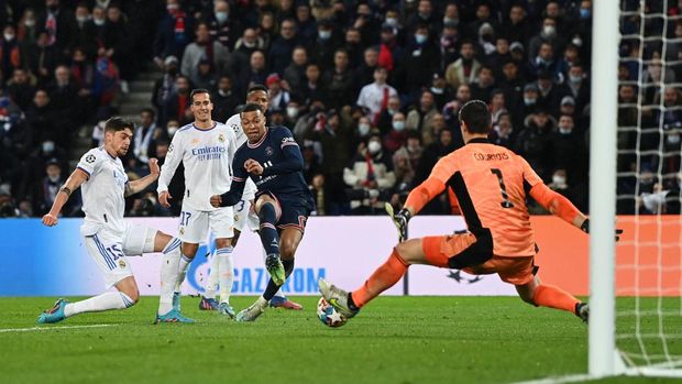 PARIS, FRANCE - FEBRUARY 15: Kylian Mbappe of Paris Saint-Germain scores their team's first goal past Thibaut Courtois of Real Madrid during the UEFA Champions League Round Of Sixteen Leg One match between Paris Saint-Germain and Real Madrid at Parc des Princes on February 15, 2022 in Paris, France. (Photo by Shaun Botterill/Getty Images)
