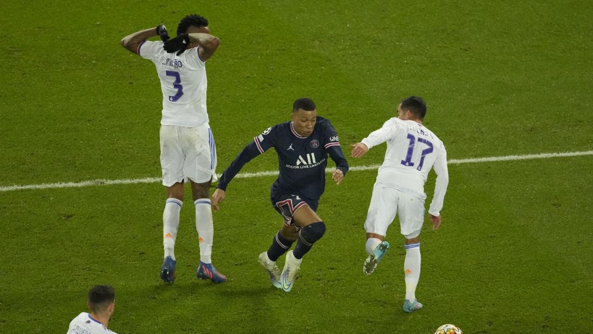 Kylian Mbappe melewati dua pemain Real Madrid untuk memenangkan PSG di menit terakhir. (Foto: AP/Francois Mori)